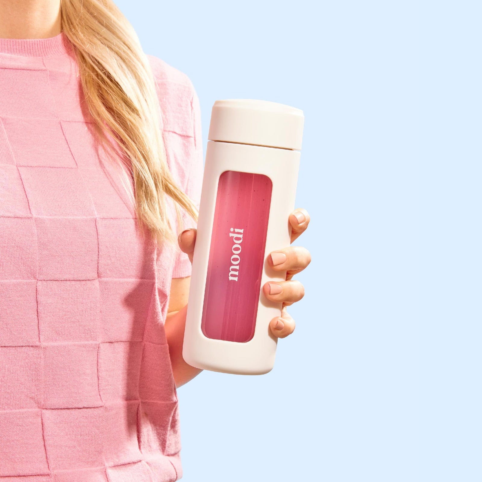 Person holding Moodi drink bottle with Pink Lemonade drink