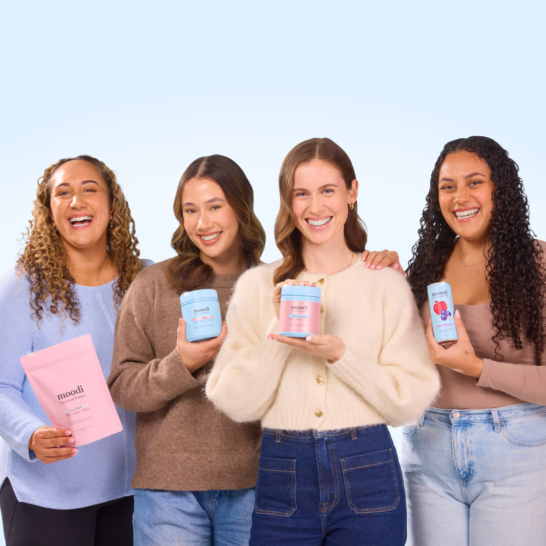 Four women holding Moodi products on a light blue background.