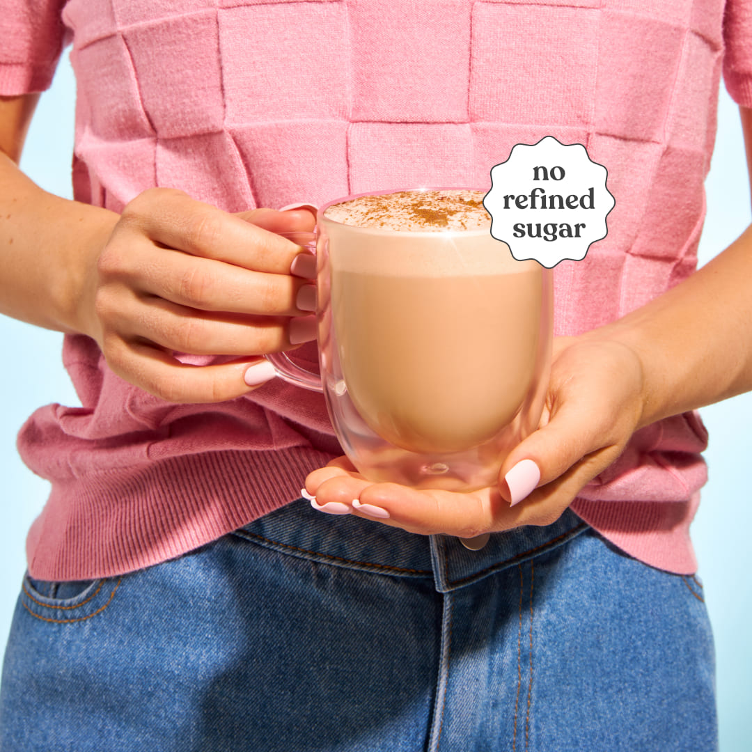 Person holding a cup of Moodi Chai with 'no refined sugar' label