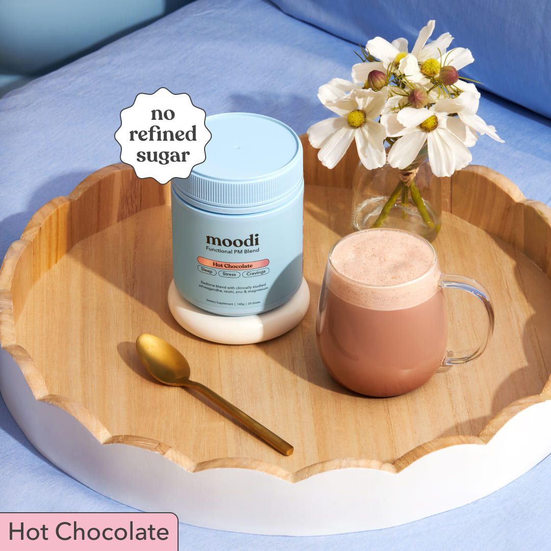 Moodi Hot Chocolate tub with a mug of hot chocolate on a wooden tray.