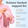 Person holding a glass of Moodi Blackcurrant Apple with text about science-backed support for gut health, stress, and mood.
