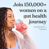 Woman drinking Moodi's Pink Lemonade from a glass with text promoting a gut health journey