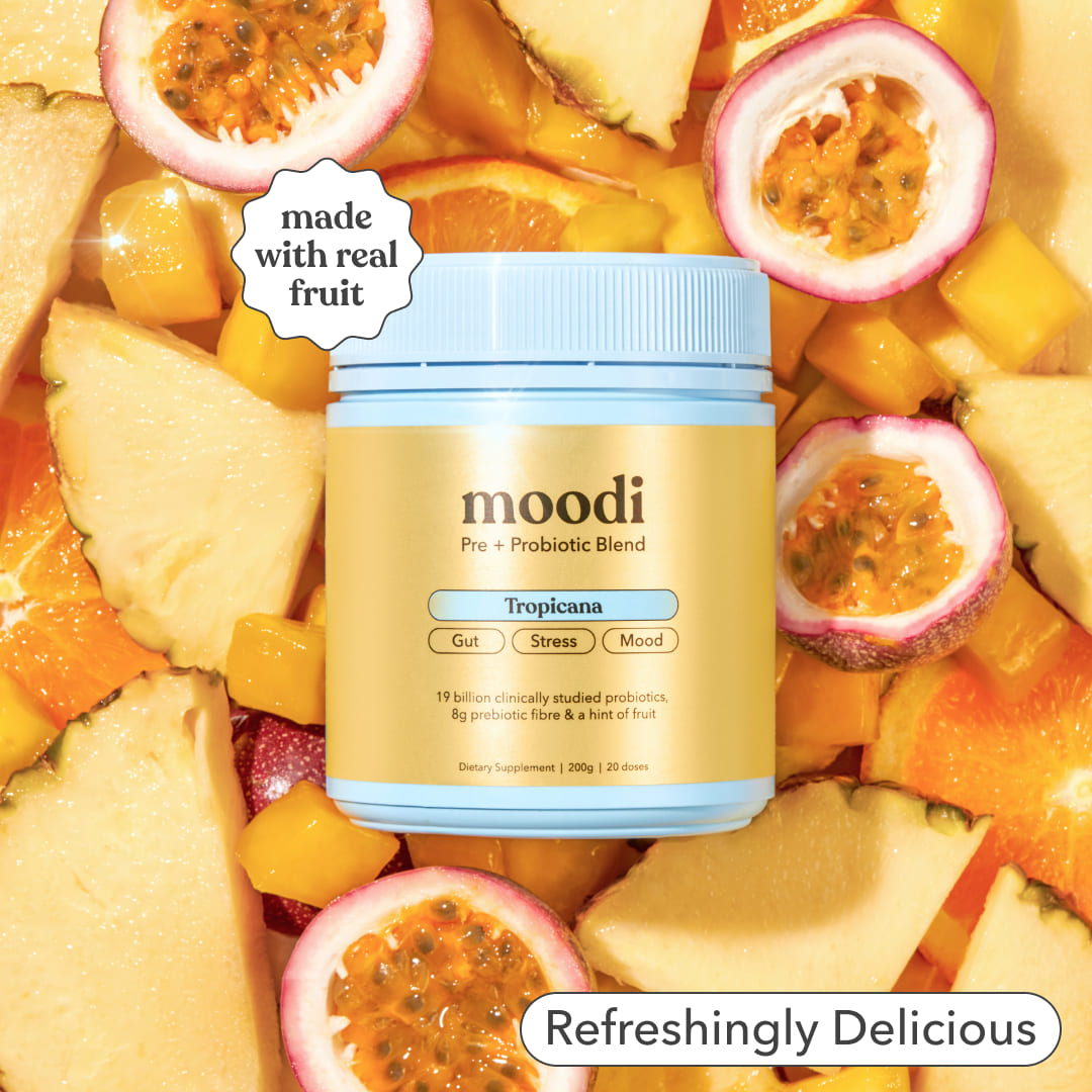 Moodi Tropicana Pre + Probiotic tub surrounded by sliced tropical fruits