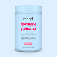 Container of moodi strawbery hormone gummies on a light blue background