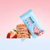 Moodi Strawberry Vanilla protein crisp bar packaging with bars and strawberries on a pink background