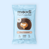 Moodi Choc Caramel Plant Protein Ball packaging on a light blue background