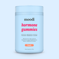 Container of moodi Peach Hormone Gummies on a light blue background
