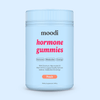Container of moodi Peach Hormone Gummies on a light blue background