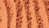 Close-up of textured brown powder with patterns