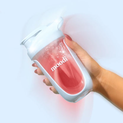 Light blue Moodi shaker filled with pink liquid being shaken